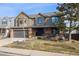 Charming two-story home featuring a brick and siding exterior, attached garage, and nicely landscaped front yard at 1711 Spring Water Ln, Highlands Ranch, CO 80129