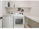 Well-organized laundry room with modern washer, dryer, and shelving at 1711 Spring Water Ln, Highlands Ranch, CO 80129