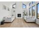 Bright living room with tall ceilings, large windows, fireplace, and hardwood floors at 1711 Spring Water Ln, Highlands Ranch, CO 80129