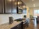 Modern kitchen with dark cabinetry, granite countertops, and stainless steel appliances at 2521 E 163Rd Pl, Thornton, CO 80602