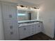 Bathroom boasts double sinks, granite counters, a large mirror, and modern vanity lighting at 61400 E 56 Ave, Strasburg, CO 80136