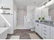 Elegant bathroom with walk-in shower, soaking tub, and double vanity with neutral color palette at 61400 E 56 Ave, Strasburg, CO 80136