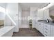Modern bathroom featuring a soaking tub, walk-in shower with marble tile, and granite countertops at 61400 E 56 Ave, Strasburg, CO 80136
