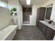 Modern bathroom featuring a shower and separate tub, dark wood vanity with double sinks and tile floors at 61400 E 56 Ave, Strasburg, CO 80136