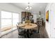 Bright dining area with a round wooden table, slider, and stylish modern chandelier at 61400 E 56 Ave, Strasburg, CO 80136