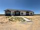 Inviting single-story home with a concrete walkway and a well-manicured lawn at 61400 E 56 Ave, Strasburg, CO 80136