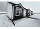 Well-maintained single-story house featuring black trim, white siding, and a landscaped yard at 61400 E 56 Ave, Strasburg, CO 80136