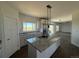 Spacious kitchen with a large center island, granite counters, and modern lighting at 61400 E 56 Ave, Strasburg, CO 80136