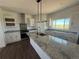 Bright kitchen featuring an island with granite countertops and modern appliances at 61400 E 56 Ave, Strasburg, CO 80136