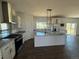 Modern kitchen with white cabinets, granite countertops, stainless steel appliances, and a large island at 61400 E 56 Ave, Strasburg, CO 80136