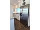 Kitchen featuring stainless steel refrigerator, white cabinets, granite countertops, and hardwood floors at 61400 E 56 Ave, Strasburg, CO 80136