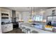 Modern kitchen boasts granite counters, stainless appliances, island with seating and a sleek lighting fixture at 61400 E 56 Ave, Strasburg, CO 80136