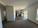Open floor plan with carpeted living room leading to a spacious kitchen and outdoor patio at 61400 E 56 Ave, Strasburg, CO 80136