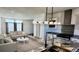 Open layout living room with luxury kitchen island featuring modern decor, couch and lighting at 61400 E 56 Ave, Strasburg, CO 80136