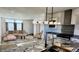 Living room with luxury kitchen island and open layout featuring modern decor, couch and lighting at 61400 E 56 Ave, Strasburg, CO 80136