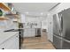 Well-equipped kitchen with stainless steel appliances, open shelving, and modern finishes at 365 S Xapary St, Aurora, CO 80012