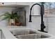 Close up of the kitchen sink area with sleek black faucet and white countertops, adding modern elegance to the space at 365 S Xapary St, Aurora, CO 80012