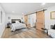 Spacious bedroom featuring a modern bed, elegant decor, and a sliding barn door to the bathroom and walk-in closet at 365 S Xapary St, Aurora, CO 80012