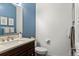 Bathroom featuring a sink with dark wood cabinetry and a blue wall at 1159 S Otis Pl, Lakewood, CO 80232