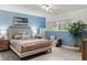 Serene bedroom with soothing blue walls, a comfortable bed, and soft natural light streaming through the window at 1159 S Otis Pl, Lakewood, CO 80232