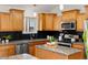 Well-lit kitchen with granite countertops, stainless steel appliances, and stylish black subway tile backsplash at 1159 S Otis Pl, Lakewood, CO 80232