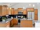 Kitchen featuring wood cabinets, granite countertops, and stainless steel appliances at 1159 S Otis Pl, Lakewood, CO 80232