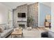 Living room with stone fireplace, plush seating, and natural light at 1159 S Otis Pl, Lakewood, CO 80232