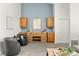 Living room with two chairs, wooden cabinetry and blue accent wall at 1159 S Otis Pl, Lakewood, CO 80232