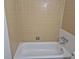 Clean bathroom showcasing a white bathtub surrounded by neutral-toned tiles at 2832 S Mobile St, Aurora, CO 80013
