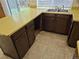 A kitchen with laminate counters, dark cabinets, and a double sink beneath a window at 2832 S Mobile St, Aurora, CO 80013