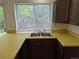 A kitchen close up of a sink, and laminate counters with dark cabinets at 2832 S Mobile St, Aurora, CO 80013