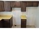 A kitchen with laminate countertops, dark cabinets, with the wiring exposed at 2832 S Mobile St, Aurora, CO 80013