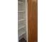 A wooden door reveals a storage closet with multiple shelves at 2832 S Mobile St, Aurora, CO 80013