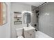 Modern bathroom featuring gray subway tile, black fixtures, and floating shelves for stylish storage at 120 W Bayaud Ave, Denver, CO 80223