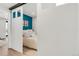 A sliding barn door leads to a bedroom with a comfortable bed and bright blue accent wall at 120 W Bayaud Ave, Denver, CO 80223