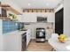 Bright kitchen with stainless steel appliances, white cabinets, blue backsplash, and breakfast nook at 120 W Bayaud Ave, Denver, CO 80223