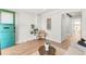 Sunlit living room features hardwood floors, a decorative plant and a green front door at 120 W Bayaud Ave, Denver, CO 80223