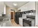 This kitchen features white cabinets, granite countertops, and black appliances at 10645 Moore Ct, Broomfield, CO 80020