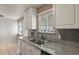This kitchen features a double basin sink and granite countertops by the window at 10645 Moore Ct, Broomfield, CO 80020