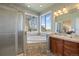 Bright bathroom with a glass enclosed shower, separate tub, large mirror, and window with views at 3519 Zane Gray Loop, Parker, CO 80138
