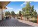 Deck with wrought iron railing overlooking playground, fire pit and treed yard at 3519 Zane Gray Loop, Parker, CO 80138