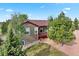 Charming exterior view of house with a back patio, stone fireplace and mature trees at 3519 Zane Gray Loop, Parker, CO 80138