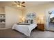 Inviting bedroom with soft carpet, ceiling fan, and light paint with backyard views from the windows and balcony door at 3519 Zane Gray Loop, Parker, CO 80138