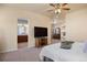 A cozy bedroom features soft carpet, ceiling fan, light paint, and entry to the bathroom with double sinks and cabinets at 3519 Zane Gray Loop, Parker, CO 80138