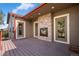 Covered patio with a stone fireplace and two doors leading inside at 3519 Zane Gray Loop, Parker, CO 80138