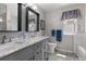 Bright bathroom featuring a double vanity with marble countertops, a window, and contemporary fixtures at 6307 Monterey Pl, Highlands Ranch, CO 80130