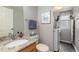 Well-lit bathroom featuring a granite countertop, stylish fixtures, and integrated laundry at 6307 Monterey Pl, Highlands Ranch, CO 80130