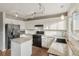 Updated kitchen with white cabinets, granite countertops, and black appliances at 6307 Monterey Pl, Highlands Ranch, CO 80130