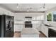 Modern kitchen with white cabinets, granite countertops, and black appliances at 6307 Monterey Pl, Highlands Ranch, CO 80130