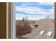 A lovely view of rooftops, snow-capped mountains and sky from inside a window at 6307 Monterey Pl, Highlands Ranch, CO 80130